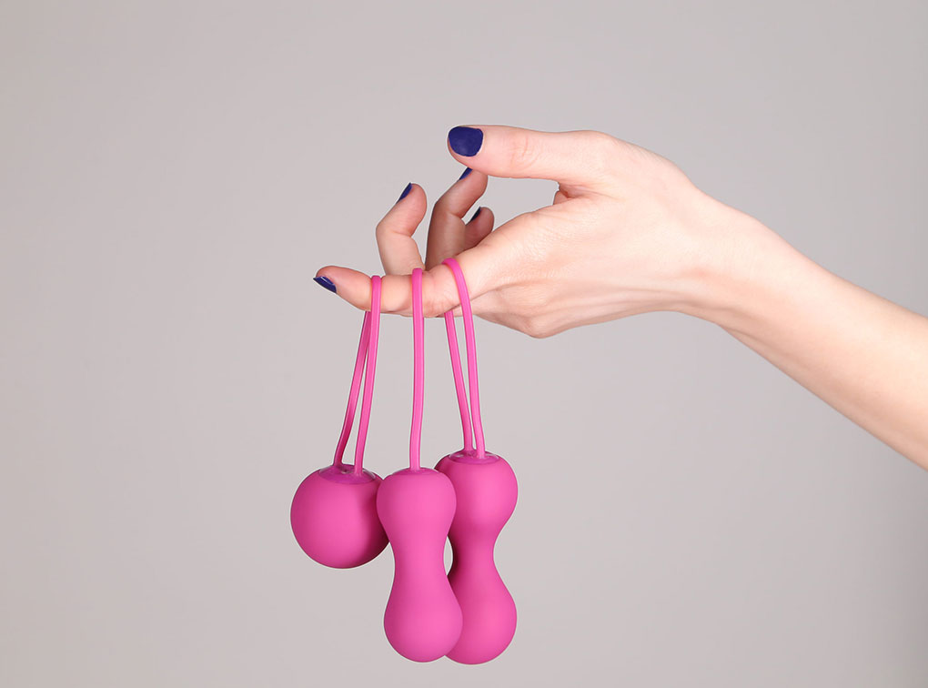 Розовые вагинальные шарики на пальце